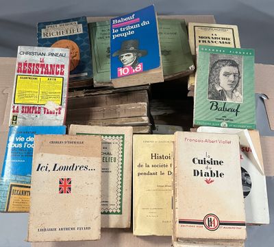 a lot of books on a table with a pen