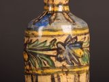 a yellow vase with a blue and green design on it