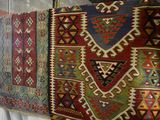 a lot of different colored rugs on display in a store