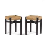 a pair of black stools with a woven seat
