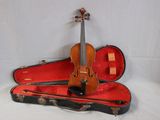 a violin and a violin case on a white surface