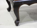 a black chair with a wooden seat on a white floor