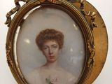 an antique picture of a woman in a white dress is shown in a gold frame