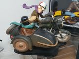 a figurine of a man riding a motorcycle with a dog on the back