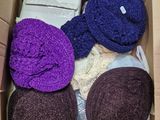 purple and purple hats in a cardboard box on a table