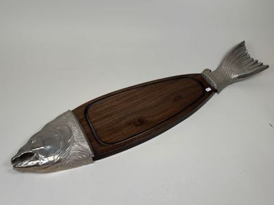 wooden and metal fish shaped serving board with a wooden handle