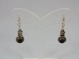 pair of black and silver earrings on display in a display case