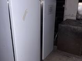 two refrigerators that are standing in a room