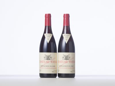 two bottles of red wine sitting next to each other on a table