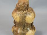 a small figurine of a woman sitting on a rock