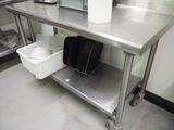 une table en métal sur laquelle est posé un sac, dans une cuisine