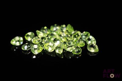 un tas de diamants verts sur une surface noire