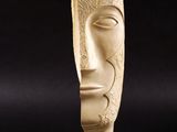 sculpture représentant le visage d'un homme, posée sur un socle en marbre, sur fond noir