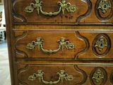 an antique chest of drawers with brass handles and a wooden top