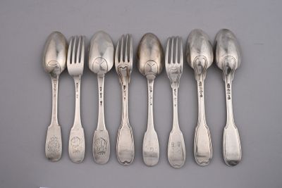 six spoons and six forks are lined up on a table