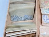 a wooden box filled with lots of stamps and envelopes