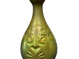 a green vase that is sitting on a white surface