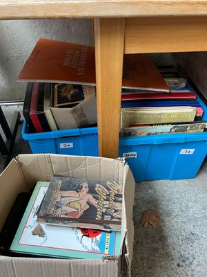 une boîte de livres posée par terre à côté d'une table