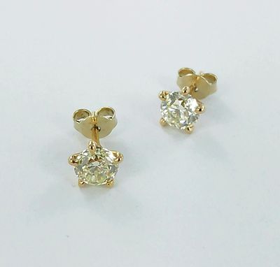 une paire de boucles d'oreilles en diamant sur une surface blanche