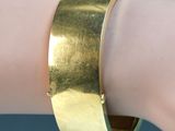 gold plated cuff bracelet on a woman ' s arm