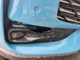 a close up of the front bumper of a blue car