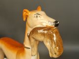 a figurine of a dog with a bagel in its mouth