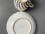 a small cup and saucer sitting on a table
