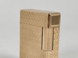 an image of a gold lighter sitting on top of a white surface