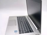 a silver laptop with a black keyboard on a white surface