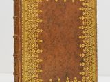 a brown and gold book sitting on top of a white table
