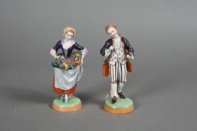 paire de figurines représentant un homme et une femme tenant des paniers de fleurs