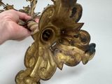 a person that is holding a gold object in their hand