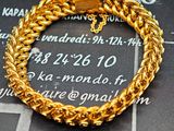 bracelet à chaîne en or orné d'une croix, sur fond noir
