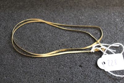 gros plan sur un collier en or portant une étiquette