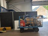 un chariot rempli de cartons dans un entrepôt dont la porte est ouverte