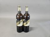 two bottles of wine sitting next to each other on a table
