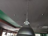 un grand luminaire métallique suspendu au plafond d'un restaurant