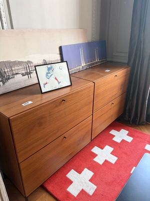 a picture of a bedroom with a red rug and a picture of a cross on the dresser