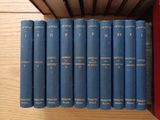 many blue books lined up on a wooden shelf