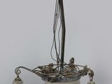 chandelier with three glass shades and a bird on top of it