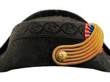 hat is black with a gold band and a red, white, and blue ribbon