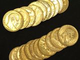 a close up of a pile of gold coins on a black surface