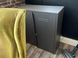 a yellow chair sitting in front of a metal cabinet