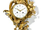 une horloge dorée posée sur une surface blanche