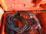une boîte à outils orange contenant un cordon et une perceuse
