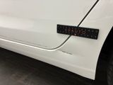 a close up of a white car with a sticker on it ' s side