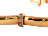 a close up of a gold bracelet with a diamond on it