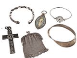 un assortiment de bijoux en argent, notamment des bagues, des bracelets et une croix