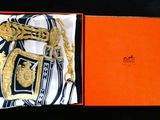 an orange box with a gold chain and a scarf in it