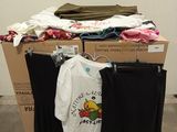 a pile of clothes on a carton in a room